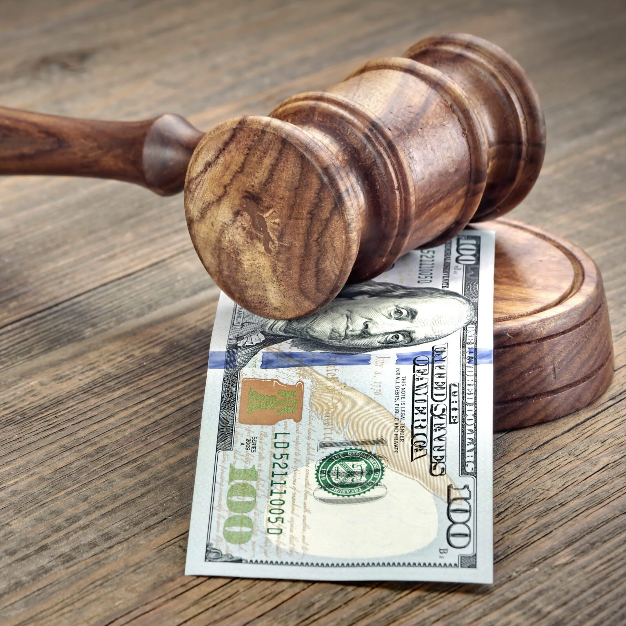 Gavel resting on a hundred-dollar bill