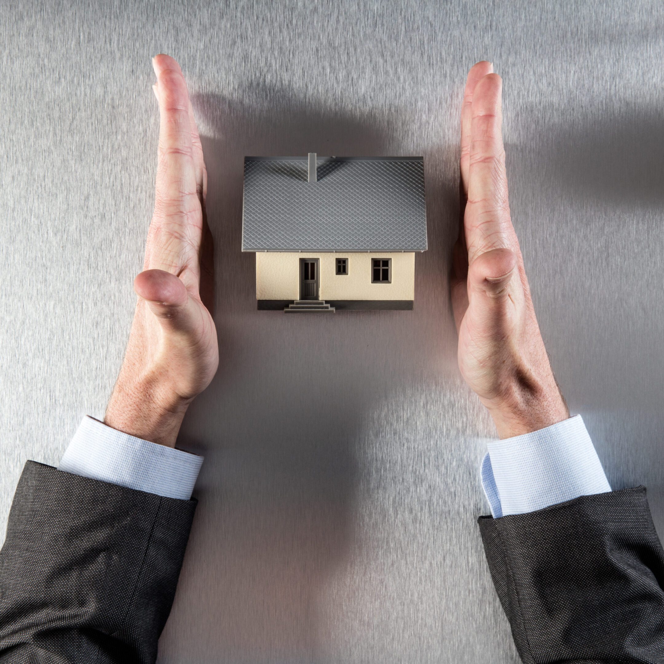Businessman safeguarding a small house